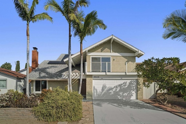 view of front of house featuring solar panels, a balcony, and a garage