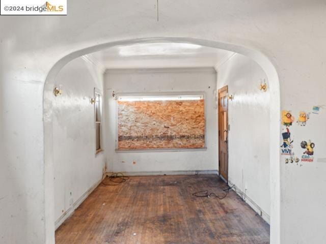 interior space featuring ornamental molding and dark wood-type flooring