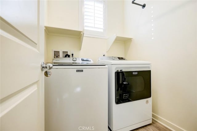 washroom featuring light wood-type flooring and washing machine and dryer