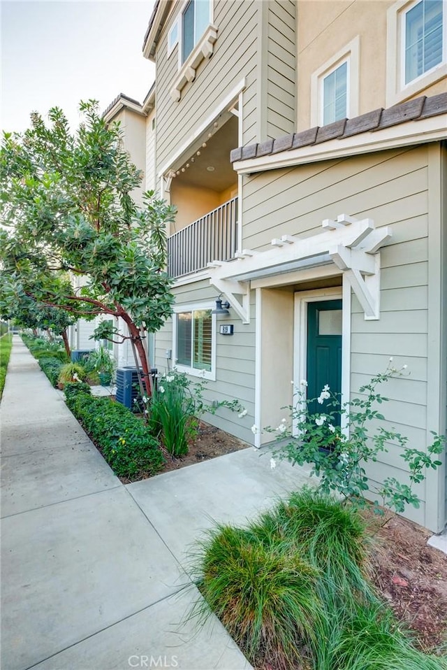 doorway to property featuring a balcony and central AC