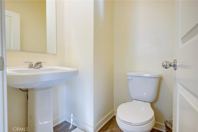 bathroom featuring hardwood / wood-style flooring and toilet