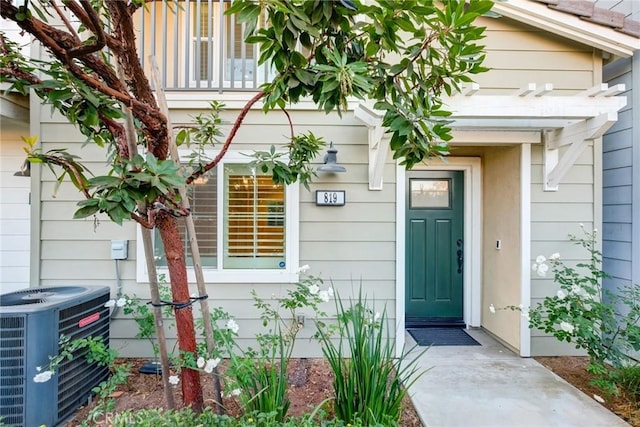 entrance to property featuring a balcony and cooling unit