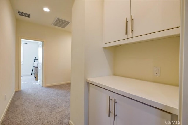 hall with light colored carpet