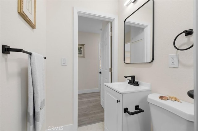 bathroom with vanity, hardwood / wood-style flooring, and toilet