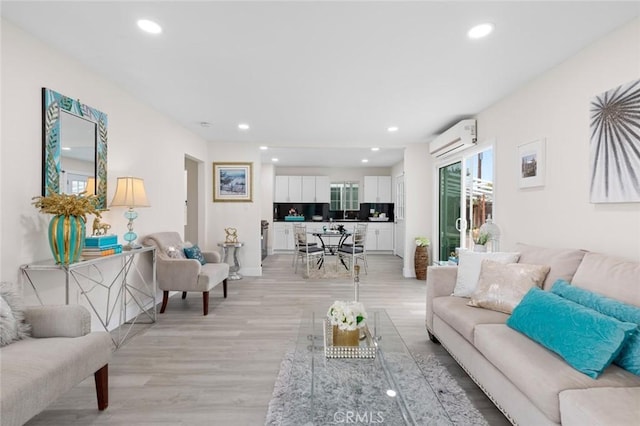 living room with light hardwood / wood-style flooring and a wall mounted air conditioner