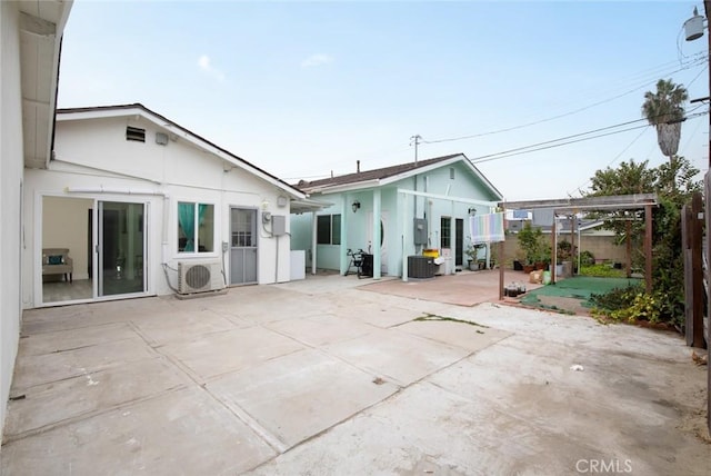 rear view of property with ac unit, central air condition unit, a patio area, a pergola, and stucco siding