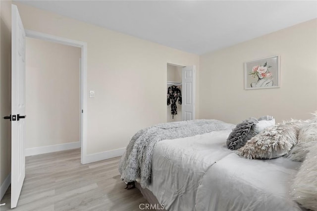 bedroom with light hardwood / wood-style flooring and a closet