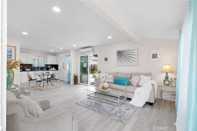 living room featuring a wall unit AC, light wood-style floors, beamed ceiling, and recessed lighting