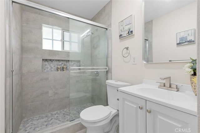 bathroom featuring walk in shower, vanity, and toilet