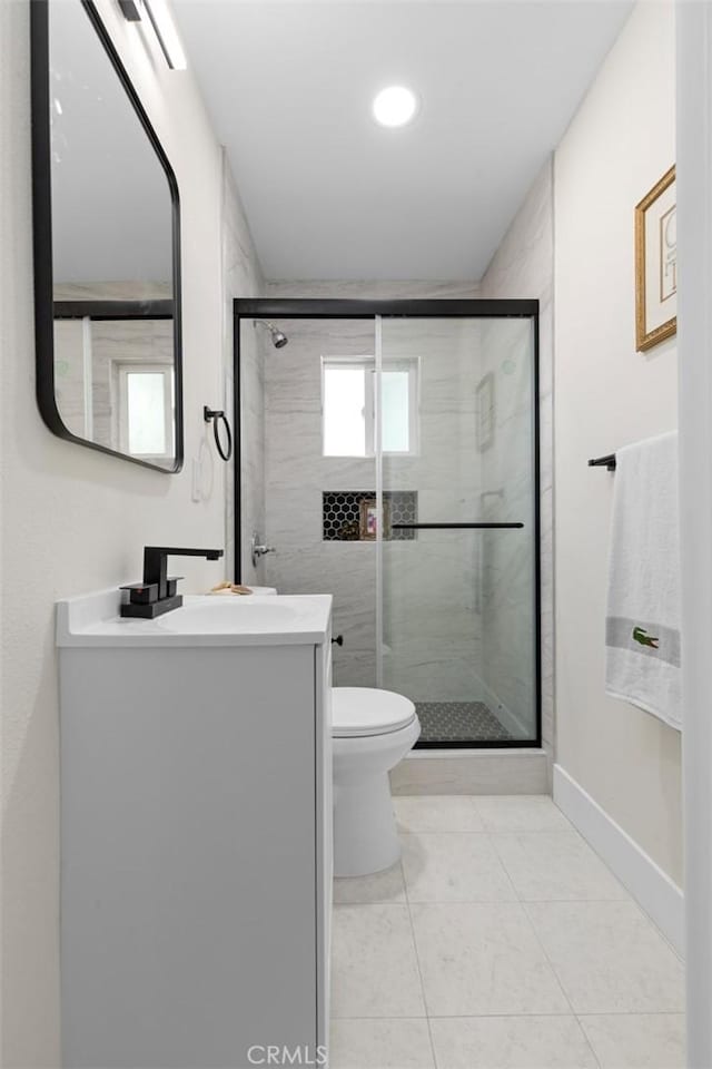 bathroom with tile patterned flooring, vanity, toilet, and an enclosed shower