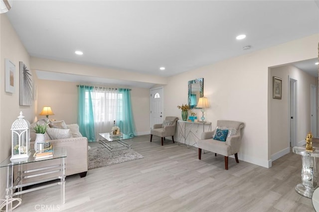 living room featuring light wood-style floors, baseboards, and recessed lighting