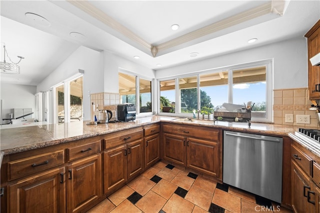 kitchen with backsplash, stainless steel dishwasher, light stone counters, a raised ceiling, and crown molding