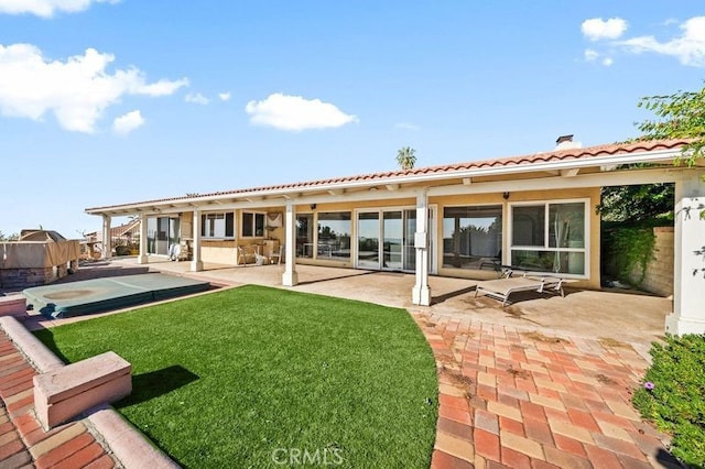 rear view of property featuring a yard and a patio