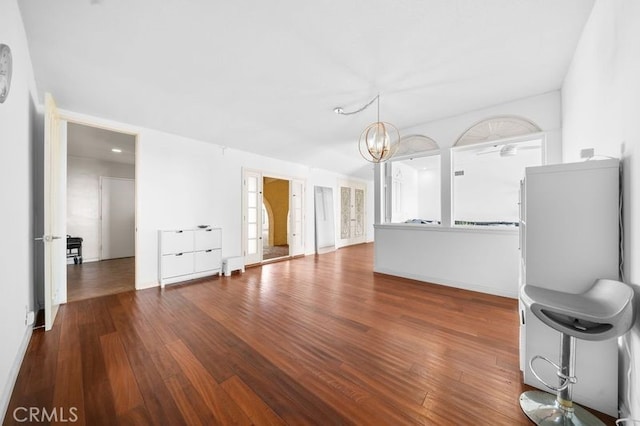 unfurnished living room featuring dark wood-type flooring and a chandelier