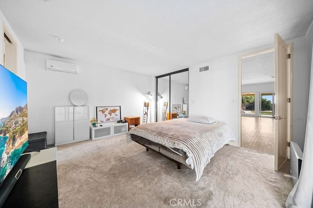 bedroom with a wall mounted air conditioner and carpet floors