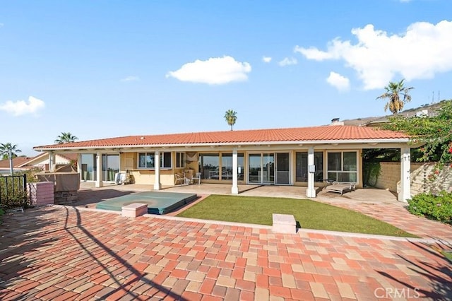 back of house with a patio and a hot tub