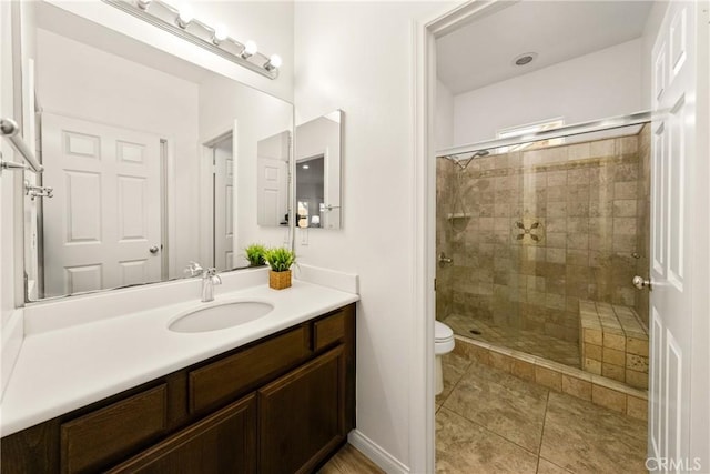 bathroom featuring tile patterned floors, vanity, an enclosed shower, and toilet