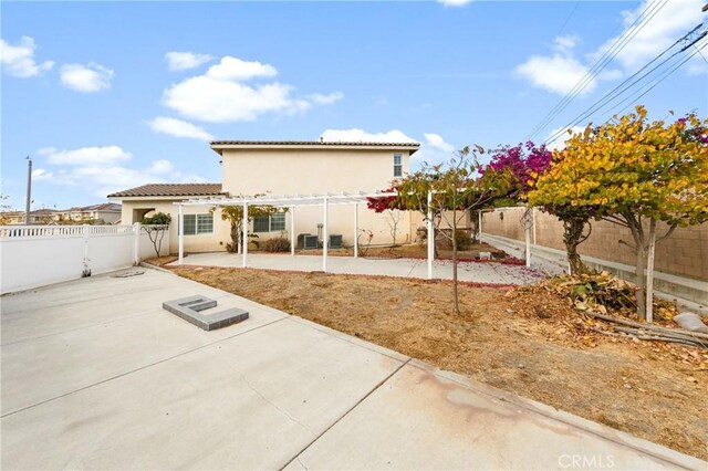 rear view of property featuring a patio and a pergola