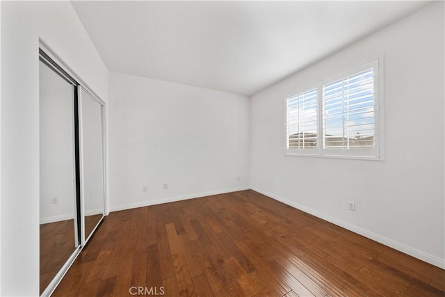 unfurnished bedroom with wood-type flooring and a closet