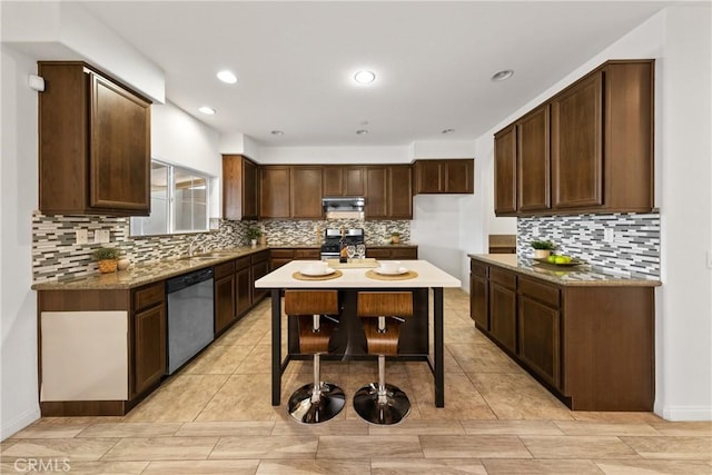 kitchen with tasteful backsplash, dark brown cabinetry, a center island, and appliances with stainless steel finishes