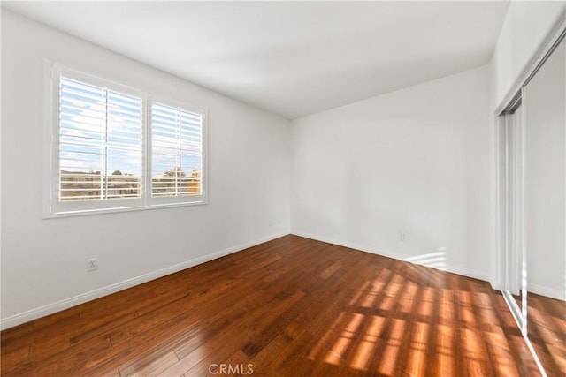 unfurnished bedroom featuring hardwood / wood-style flooring and a closet