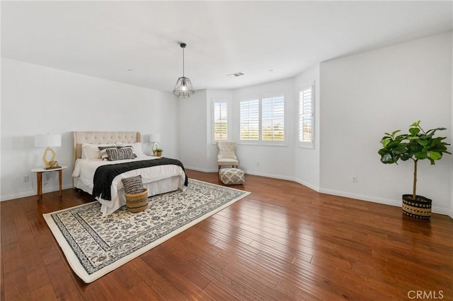 bedroom with wood-type flooring, visible vents, and baseboards