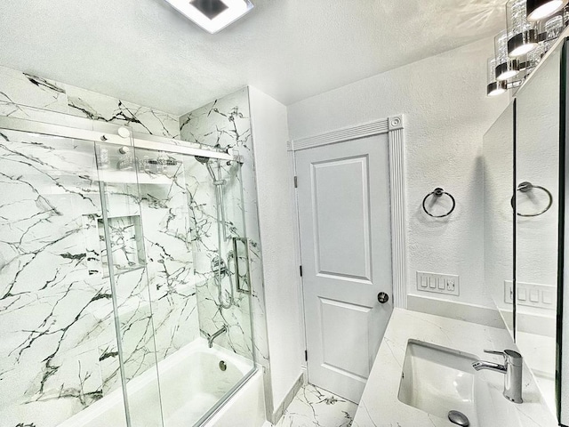 bathroom with vanity, bath / shower combo with glass door, and a textured ceiling