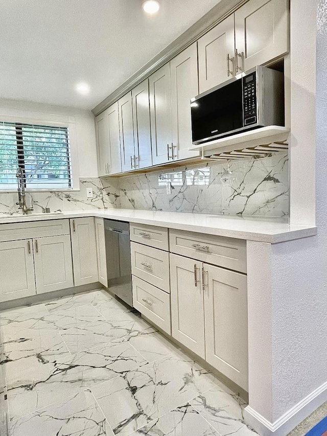 kitchen with sink, appliances with stainless steel finishes, and tasteful backsplash