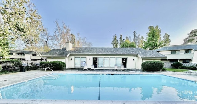 rear view of house with a community pool