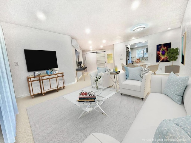 living room with a barn door, light colored carpet, and a textured ceiling