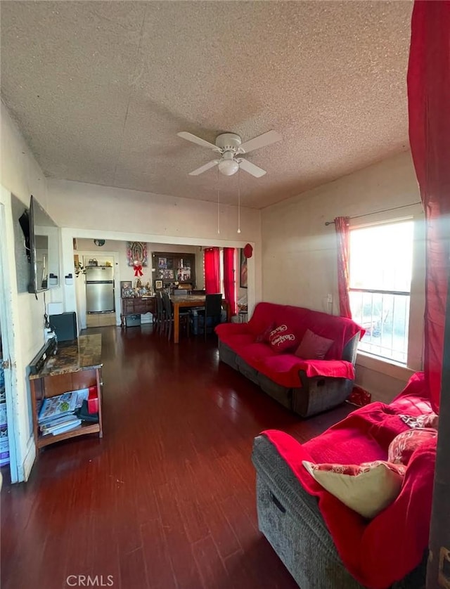 living room with hardwood / wood-style floors, a textured ceiling, and ceiling fan