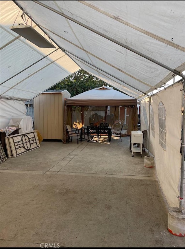 view of patio / terrace featuring a gazebo and a storage unit