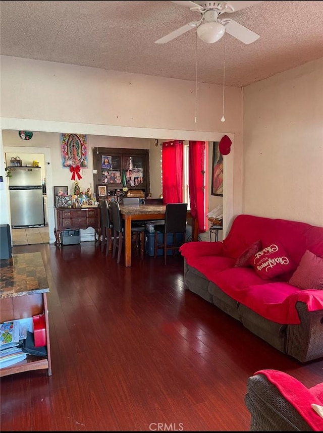 living room with hardwood / wood-style flooring, ceiling fan, and a textured ceiling