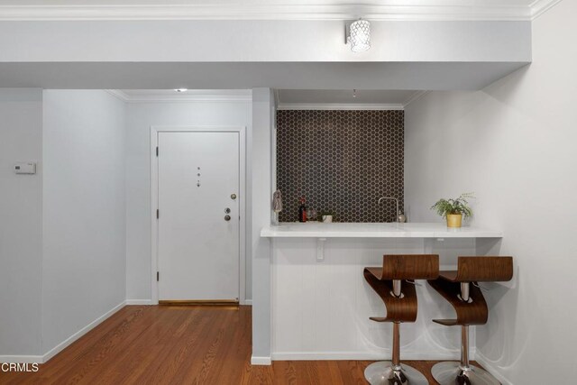 kitchen featuring hardwood / wood-style floors and crown molding