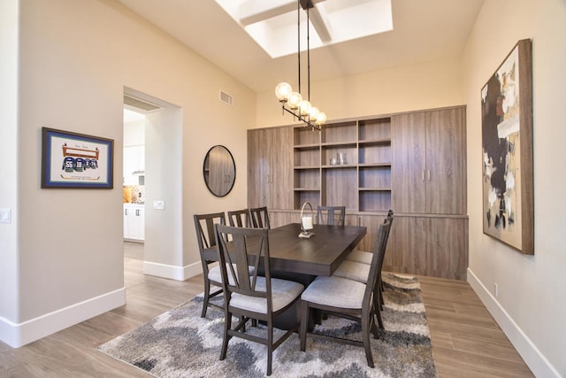 dining room with hardwood / wood-style floors and an inviting chandelier