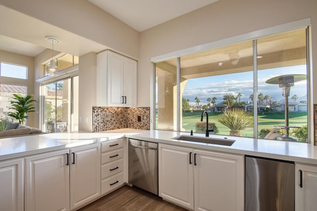 kitchen with hanging light fixtures, sink, stainless steel appliances, and a wealth of natural light