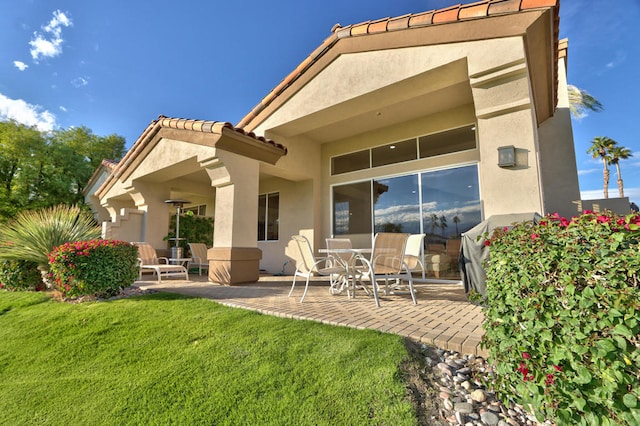 rear view of house with a patio area and a yard