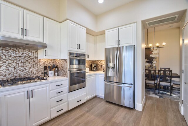 kitchen with white cabinets, light wood-type flooring, and stainless steel appliances