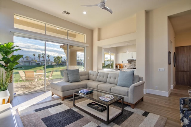 living room with ceiling fan and light hardwood / wood-style floors