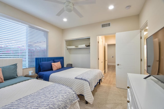 bedroom featuring ceiling fan, multiple windows, light carpet, and a closet