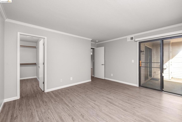 empty room featuring crown molding and hardwood / wood-style floors