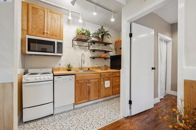 kitchen featuring track lighting, white appliances, sink, and dark wood-type flooring