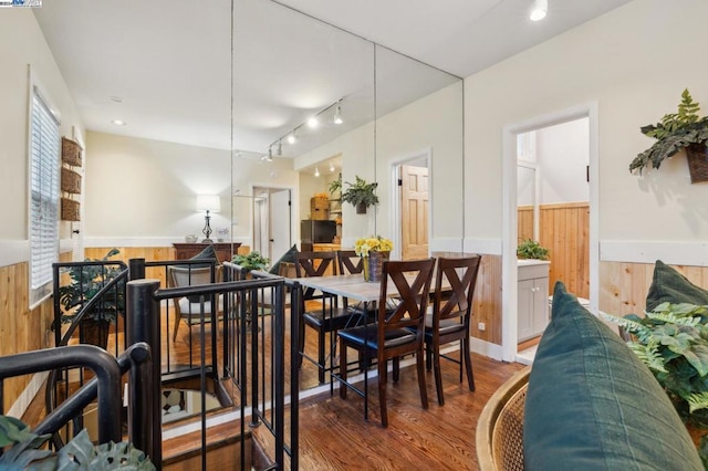 dining room with hardwood / wood-style floors and wooden walls