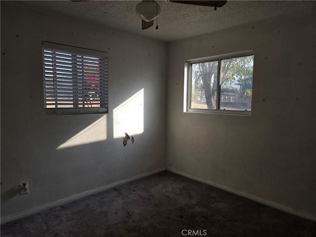 empty room with a textured ceiling, carpet floors, and ceiling fan