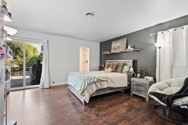 bedroom featuring dark hardwood / wood-style floors, access to exterior, and ensuite bath