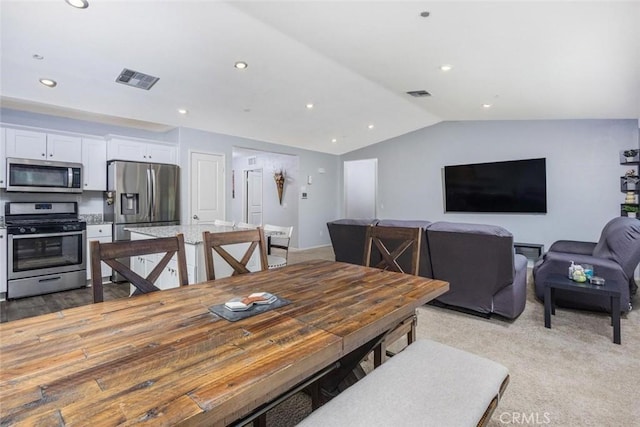 dining room with light colored carpet and lofted ceiling