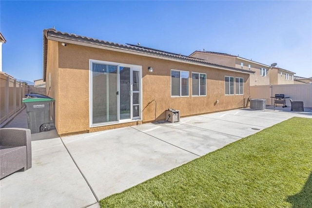 back of house with a lawn, a patio area, and central AC unit