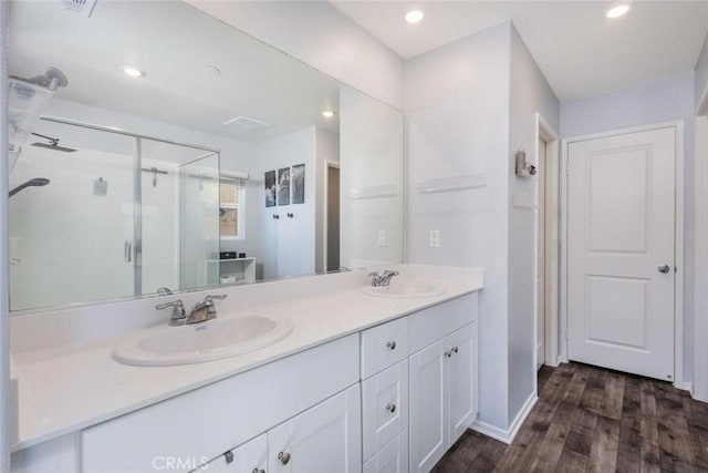 bathroom featuring wood-type flooring, vanity, and a shower with door