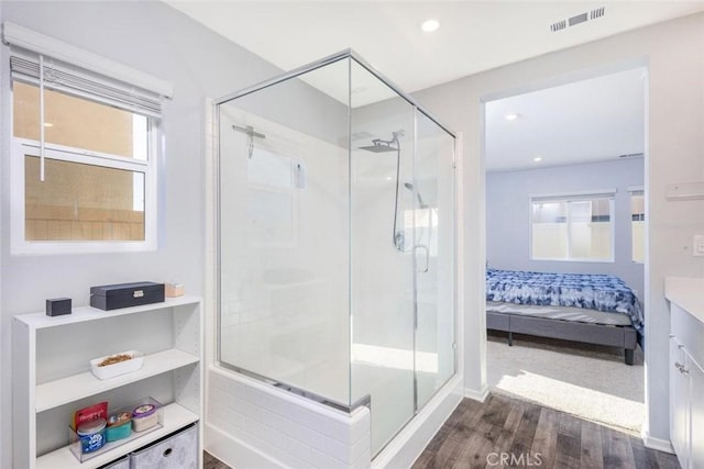 bathroom with vanity, hardwood / wood-style flooring, and a shower with shower door