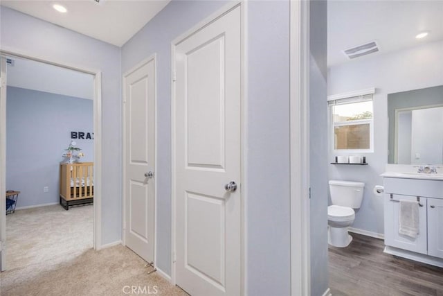 bathroom featuring hardwood / wood-style floors, vanity, and toilet